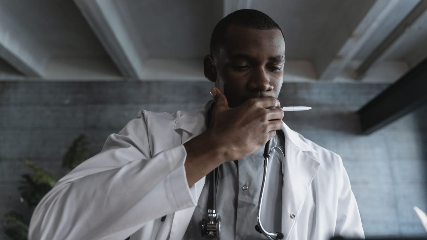 Médico pensativo em um consultório, em atitude reflexiva